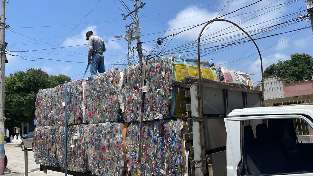 Camión cargado con pacas de plástico compactado