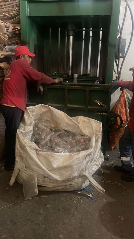 Reciclador operando la prensa de aplanado